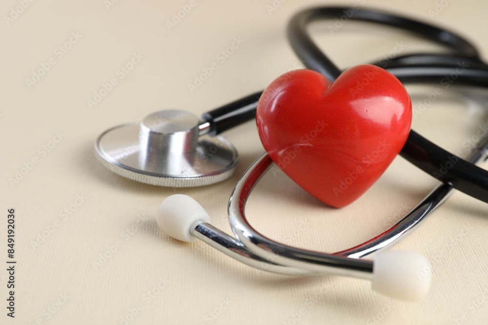 Stethoscope and red heart on beige background Stethoscope and red heart on beige background