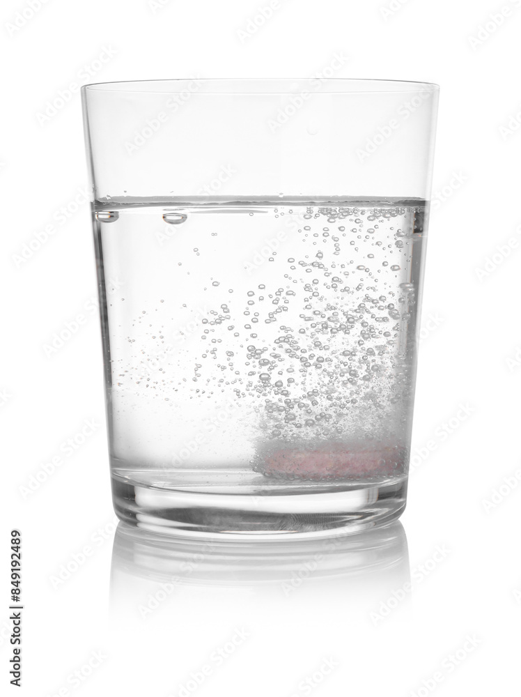 Effervescent pill dissolving in glass of water isolated on white Effervescent pill dissolving in glass of water isolated on white