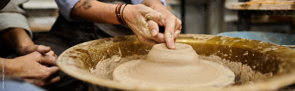 Fototapeta premium Two women work on pottery in a studio.