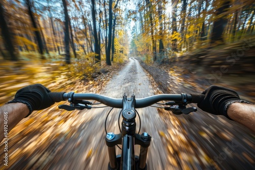 A thrilling first-person view of a mountain biker speeding through a forest path on a sunny fall day, with golden leaves falling around them
