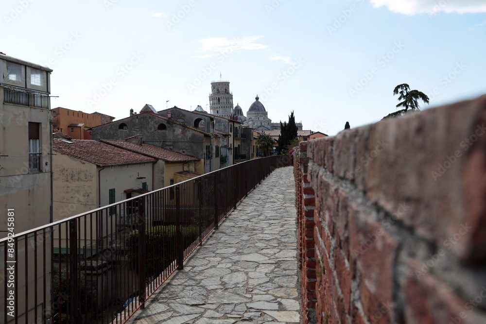 Obraz premium The Cathedral and the Leaning Tower seen from the ancient city walls of Pisa, Italy.