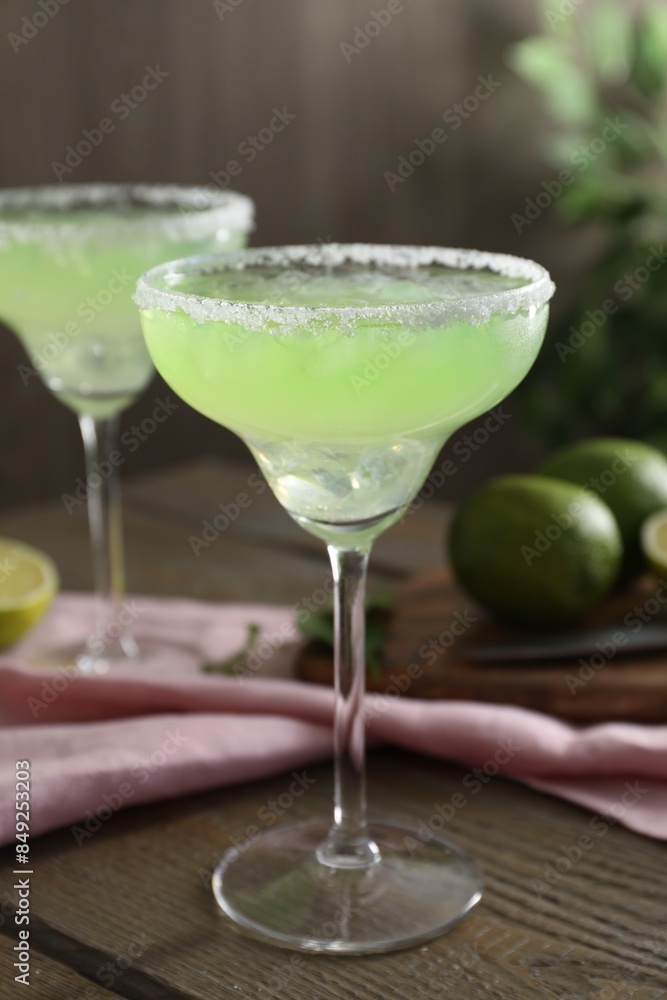 Delicious Margarita cocktail in glass on wooden table, closeup Delicious Margarita cocktail in glass on wooden table, closeup