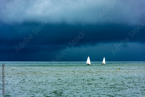 Sailboats sailing the waters of the sea of ​​Ilhabela island before the storm