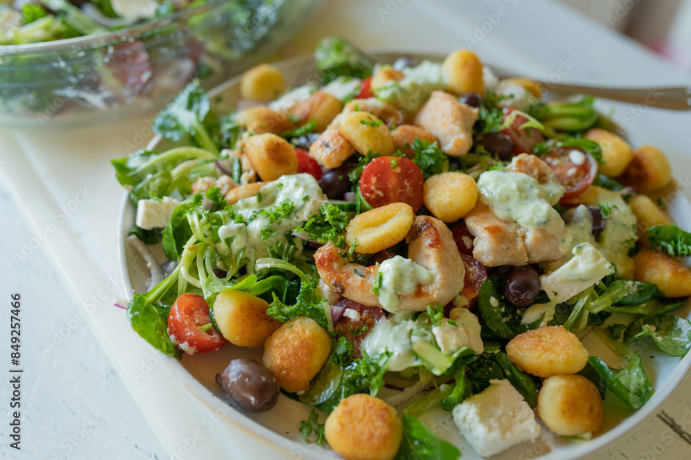 Delicious summer salad with chicken meat, vegetables, feta cheese, gnocchi and dressing Delicious summer salad with chicken meat, vegetables, feta cheese, gnocchi and dressing