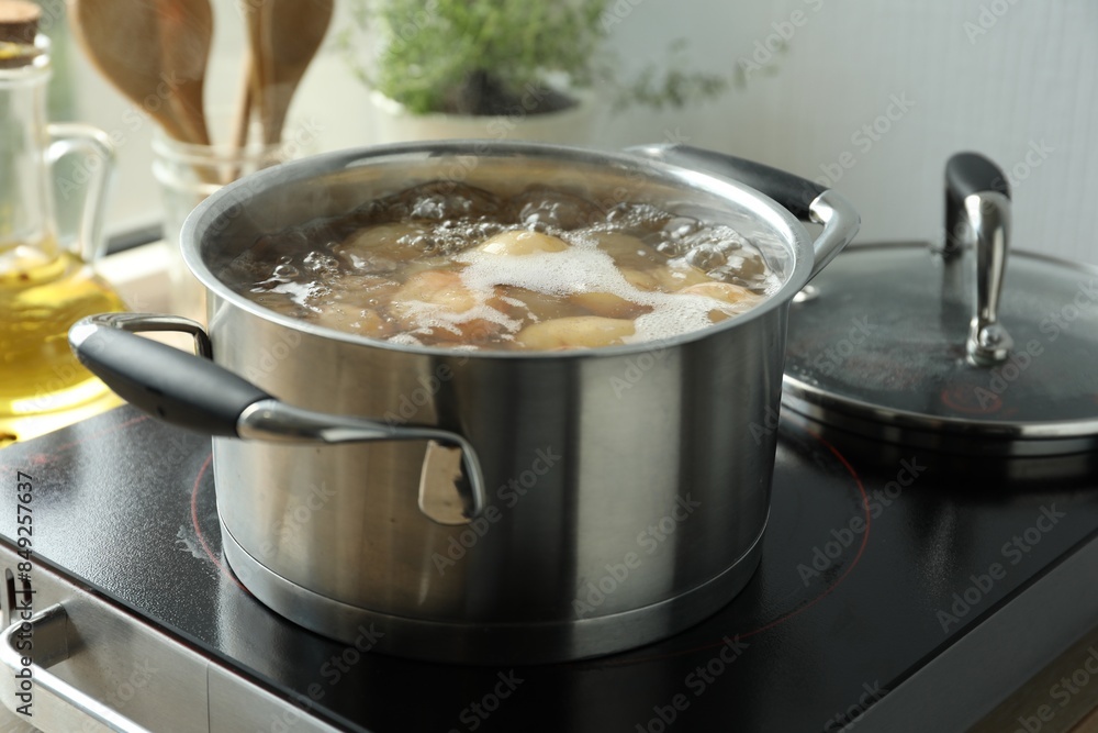 Boiling potatoes in pot on stove in kitchen Boiling potatoes in pot on stove in kitchen
