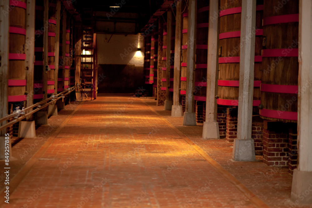 Rustic wine cellar with large aging barrels in a historical vineyard. Perfect for wine-related media. Rustic wine cellar with large aging barrels in a historical vineyard. Perfect for wine-related media.