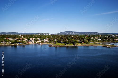 the Inner Oslofjord, near Oslo, Norway on a clear day with dark blue sea and sky with wooded hills and red roof houses