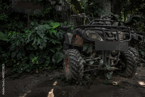 Fotografia Old broken dirty military jeep crashed into a tree in jungle tropical trees and