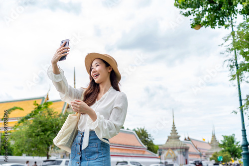Фототапет Joyful Asian Woman Taking Selfie at Famous Thai Landmark