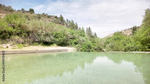 A beautiful lake with a green hill in the background. The water is clear and calm. The scene is peaceful and serene photo