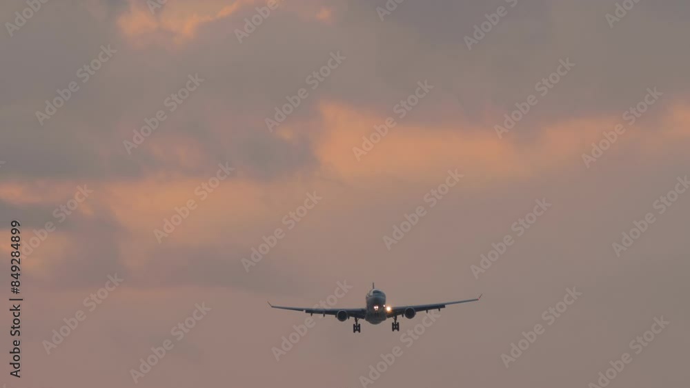 Jet plane with unrecognizable livery approaching landing in pink sunset. Aircraft is flying, descending Jet plane with unrecognizable livery approaching landing in pink sunset. Aircraft is flying, descending