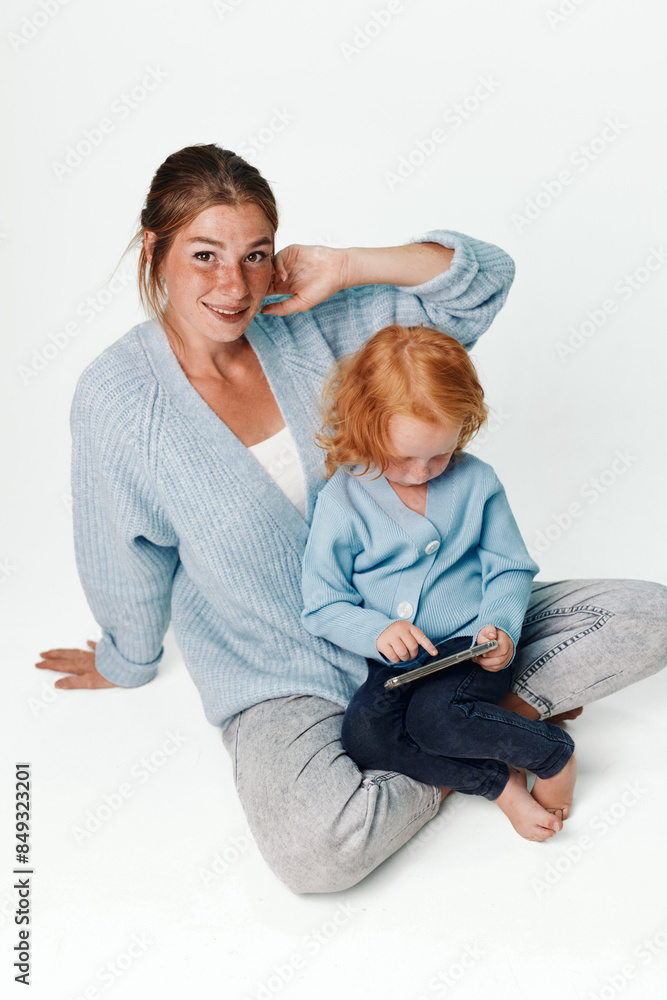 Learning together mother and daughter using tablet at home in cozy living room environment Learning together mother and daughter using tablet at home in cozy living room environment