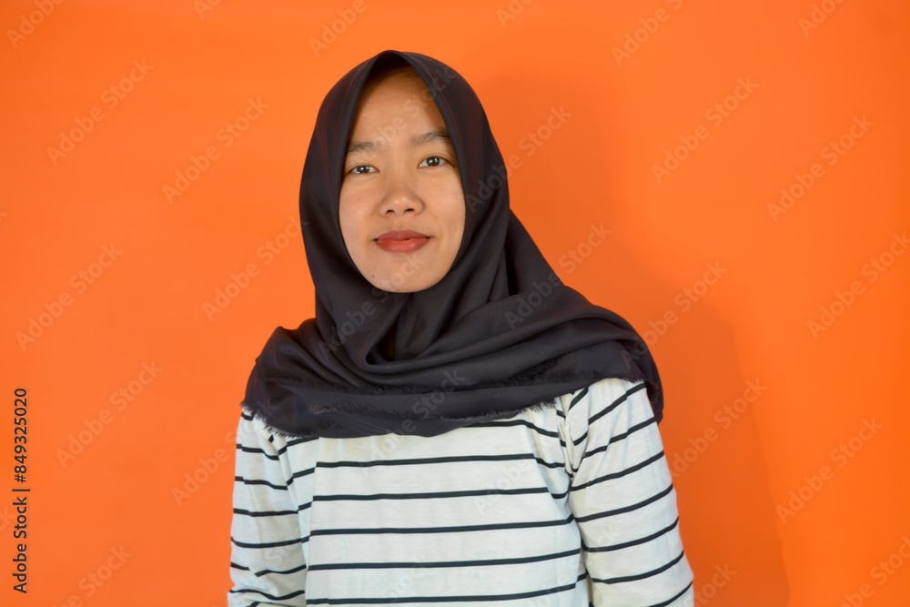A Muslim Asian woman wearing a white shirt and black hijab is standing with a confident digital gesture giving coaching A Muslim Asian woman wearing a white shirt and black hijab is standing with a confident digital gesture giving coaching