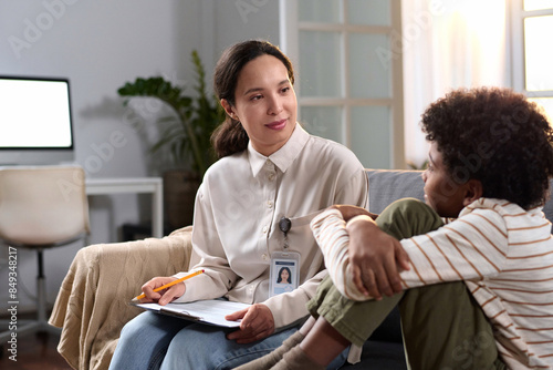 Obraz na plátne Portrait of female psychologist talking to young child in therapy session for me