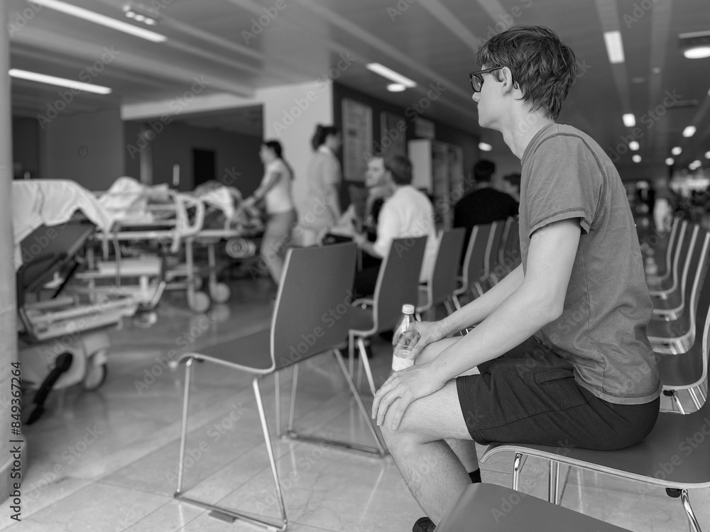 young man sitting waiting in the hospital waiting roomb black and white photo young man sitting waiting in the hospital waiting roomb black and white photo