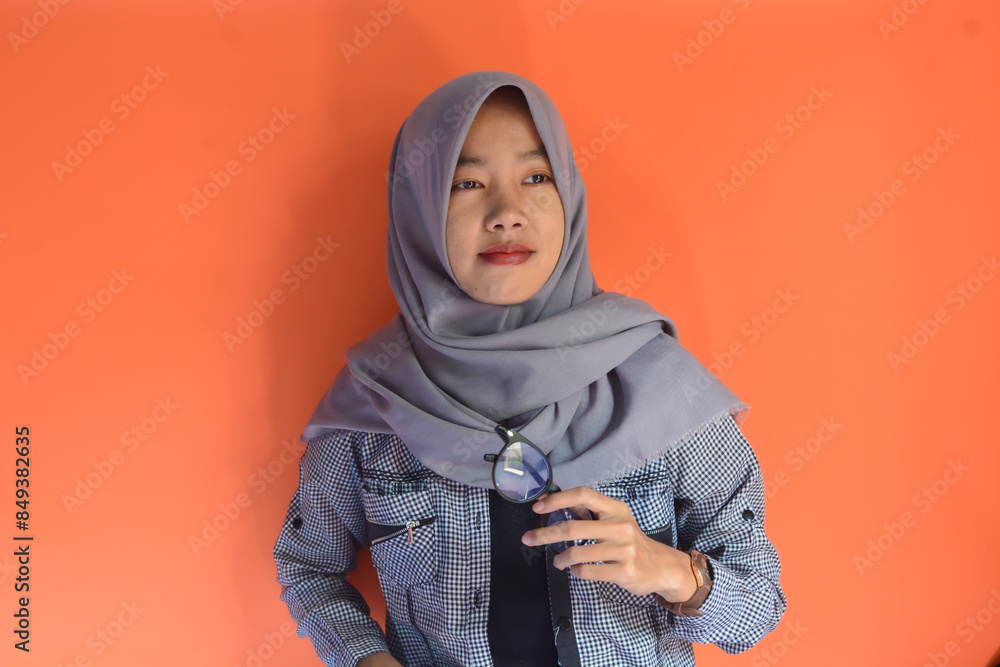 Portrait of a beautiful Asian Muslim woman who is quite thin and looks like a happy, proud and satisfied person Portrait of a beautiful Asian Muslim woman who is quite thin and looks like a happy, proud and satisfied person