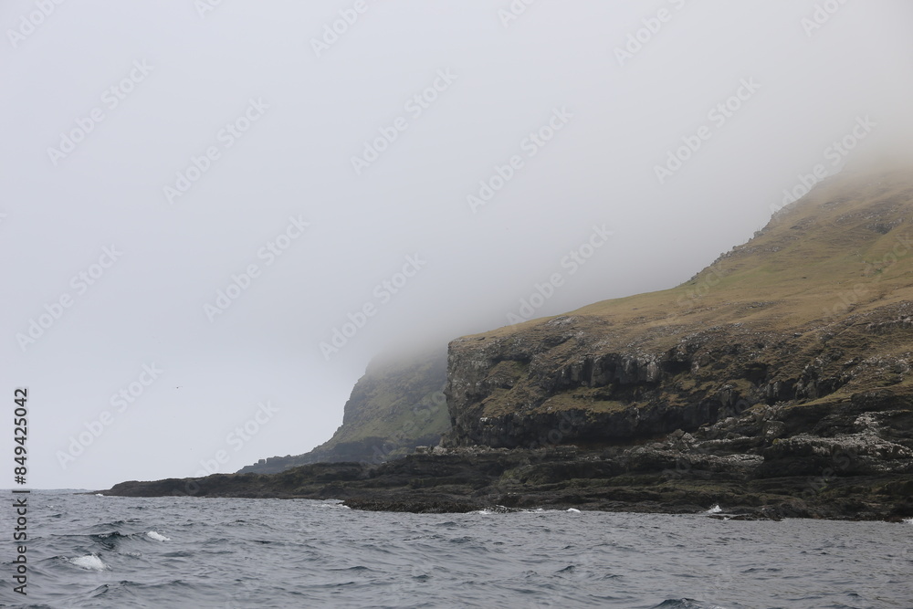 Foggy shore of Sandoy Island from the ocean, Faroe Islands Foggy shore of Sandoy Island from the ocean, Faroe Islands