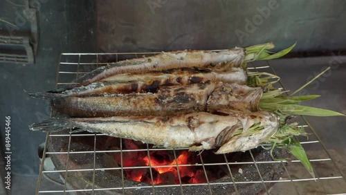 Slow Rotating Shot of Grilled Snakehead Fish Stuffed with Lemongrass on Charcoal Stove