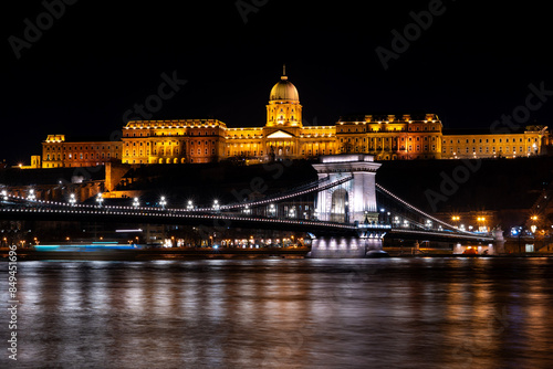 The historical Buda castle district above the Danube river illuminated by lights at night in Budapest	 photo