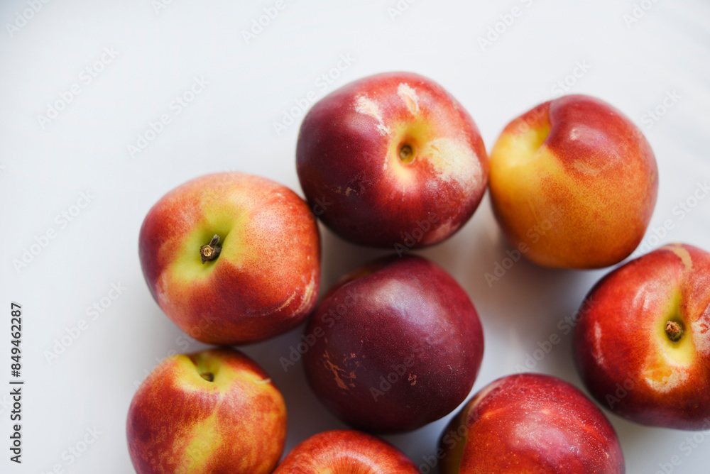 Red and yellow plums on a white background. Red and yellow plums on a white background.