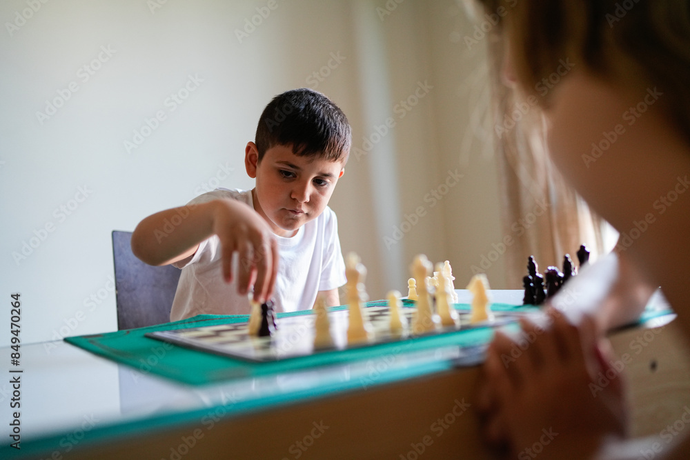 A boy is playing chess with a girl A boy is playing chess with a girl