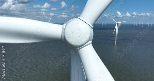 Offshore wind turbine, turning, close up view. Green sustainable energy. Wind park on sea. Aerial view.