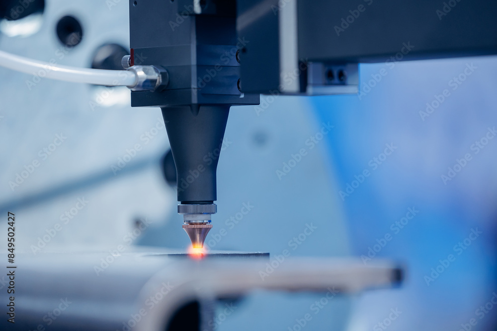 Laser CNC cut of metal with light spark. Technology modern industrial blue color Laser CNC cut of metal with light spark. Technology modern industrial blue color