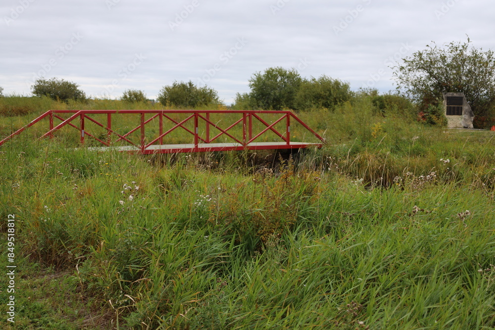 steel and wood bridge spanning a channel in prairie grass land steel and wood bridge spanning a channel in prairie grass land