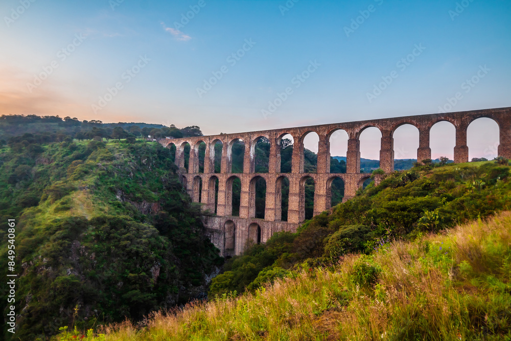 Obraz premium Aqueduct between mountains at sunrise with cloudy sky in arcos del sitio in tepotzotlan state of mexico 