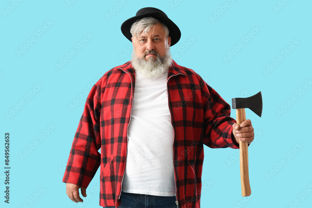 Portrait of mature lumberjack with axe on blue background Portrait of mature lumberjack with axe on blue background