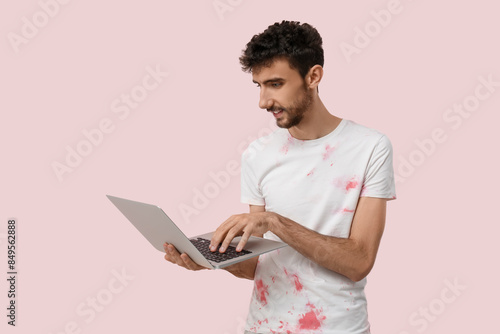 Handsome man using laptop o...