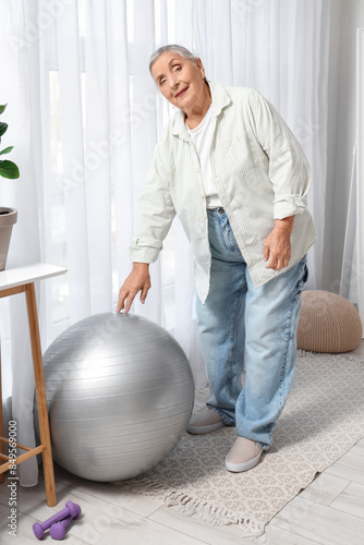 Senior woman with fitball i...
