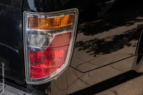 Rear stop lights of big pick up black car closeup