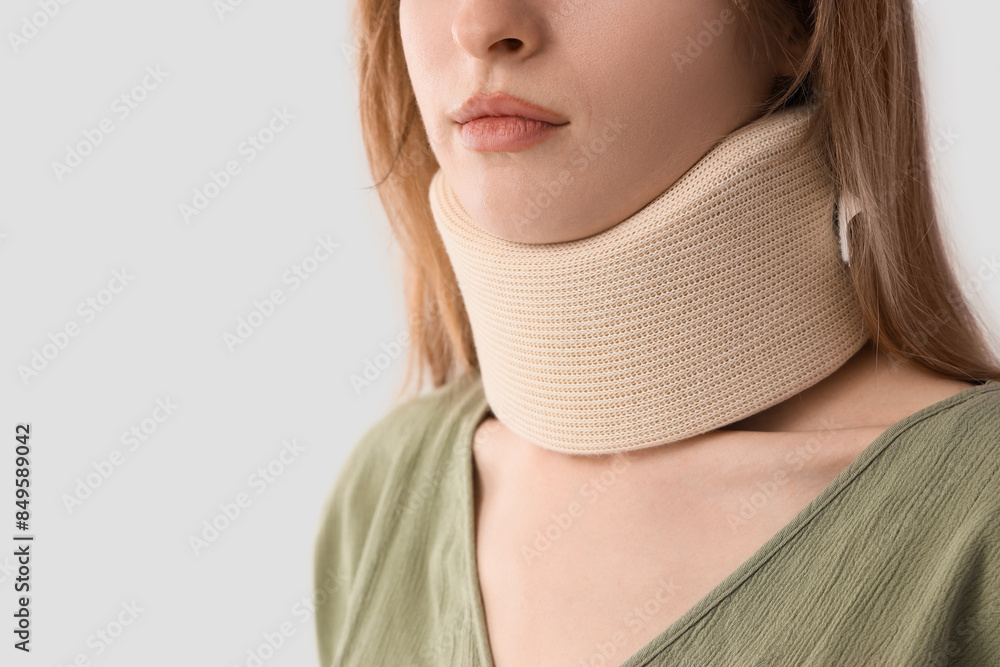 Injured young woman with cervical collar after accident on light background, closeup Injured young woman with cervical collar after accident on light background, closeup
