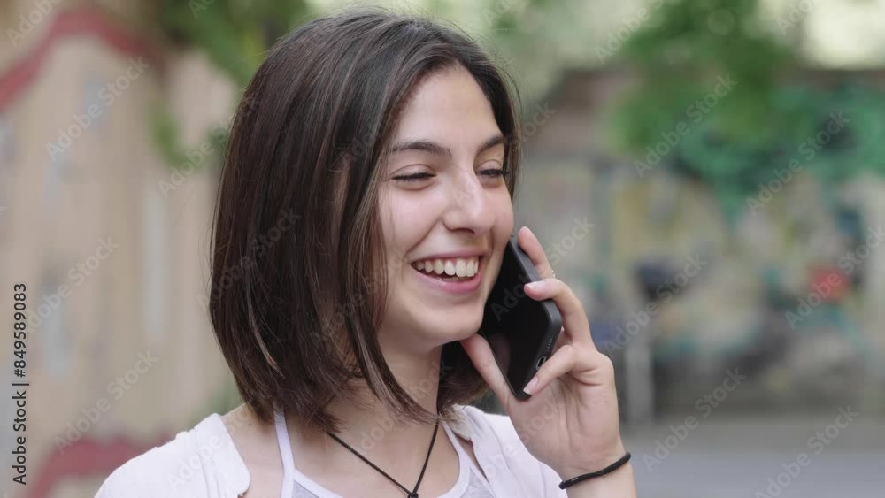 Young woman talking on phone in urban setting Young woman talking on phone in urban setting
