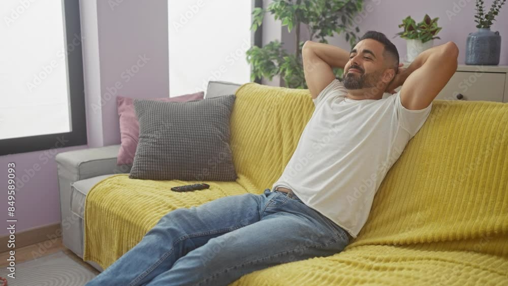 Relaxed hispanic man watching tv in a modern apartment living room Relaxed hispanic man watching tv in a modern apartment living room