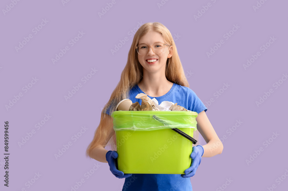 Female volunteer holding recycle bin with paper on lilac background Female volunteer holding recycle bin with paper on lilac background