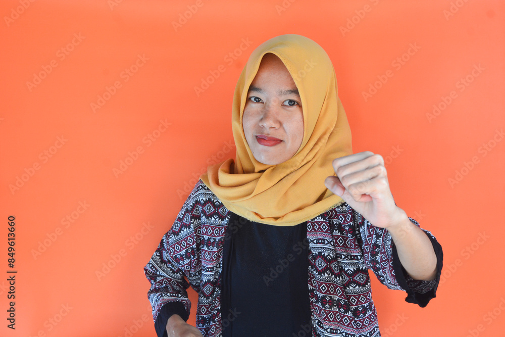 Portrait of a young Asian woman wearing a hijab with a gesture of resistance Portrait of a young Asian woman wearing a hijab with a gesture of resistance