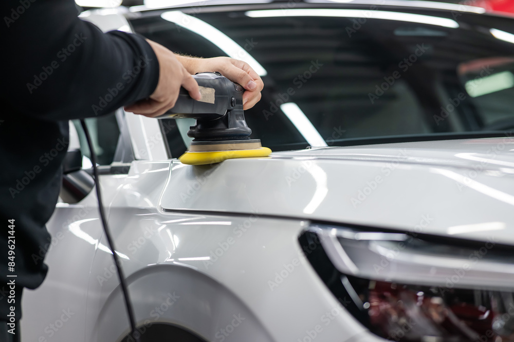 Process of polishing white car hood surface using orbital polishing machine. Process of polishing white car hood surface using orbital polishing machine.