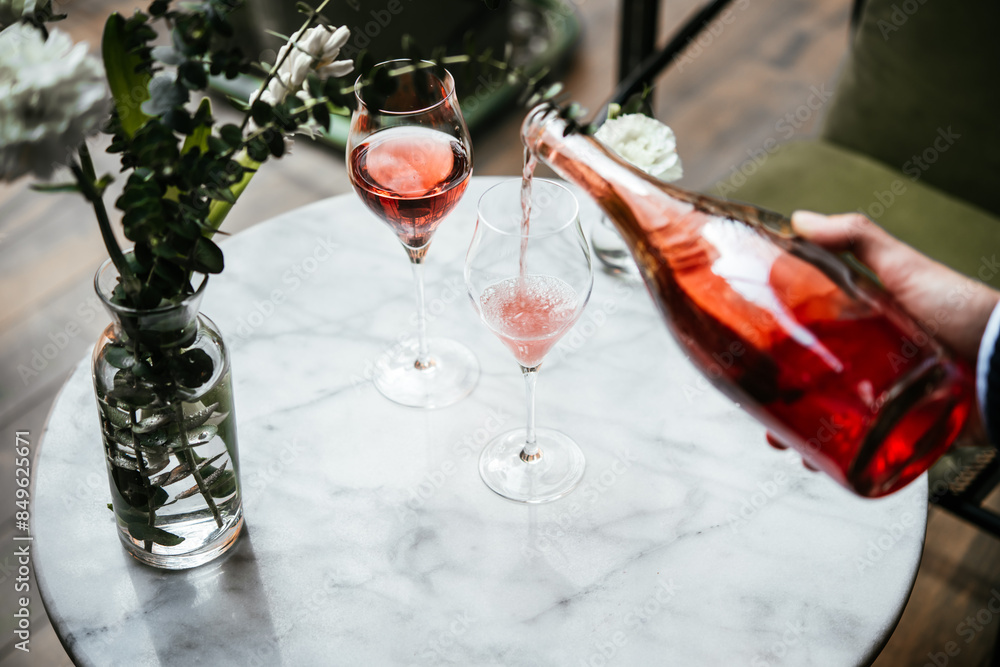 Pouring champagne at a dinner party or a date in a restaurant.