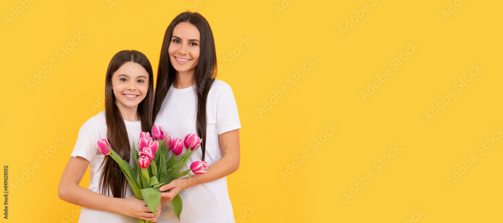 Mother and daughter child banner, copy space, isolated background. happy mother and daughter with tulip flowers on yellow background. Mother and daughter child banner, copy space, isolated background. happy mother and daughter with tulip flowers on yellow background.