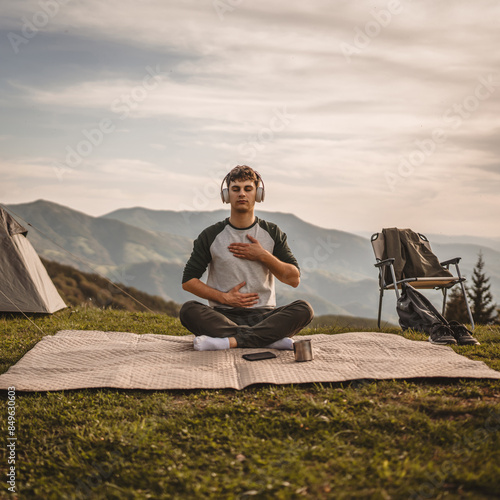 Young boy have guided meditate on the mountain in front tent