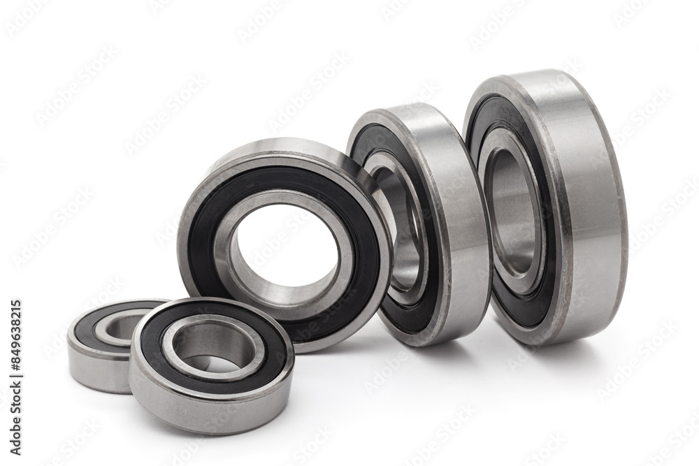 A collection of assorted tapered roller bearings of various sizes, isolated on a white background. A collection of assorted tapered roller bearings of various sizes, isolated on a white background.