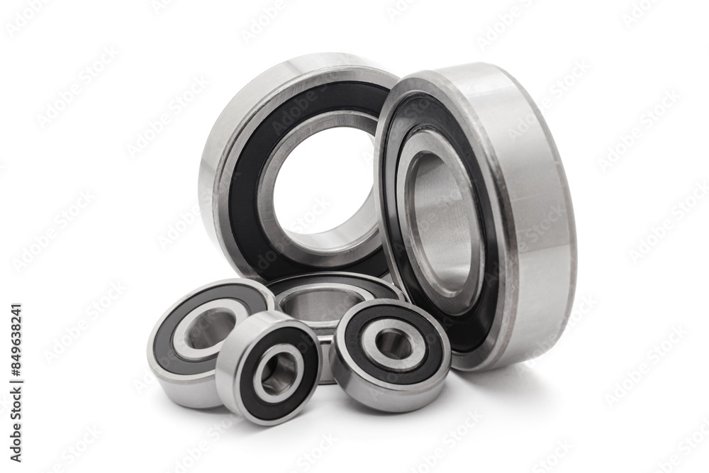 A collection of assorted tapered roller bearings of various sizes, isolated on a white background. A collection of assorted tapered roller bearings of various sizes, isolated on a white background.