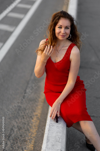 Happy self confident beautiful attractive sexy young woman in a red dress. Happiness, freedom, confidence. Sunset, summer © ArtSys
