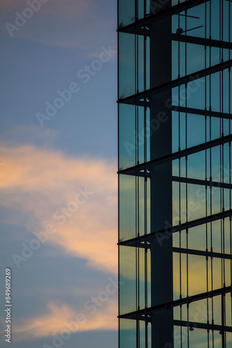 Stimmungsvolle Detailaufnahme einer modernen Glasfassade in München bei Sonnenuntergang mit Wolken