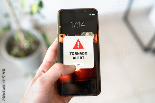 New tornado alert notification on the smart phone. Bad weather and strong wind concept.