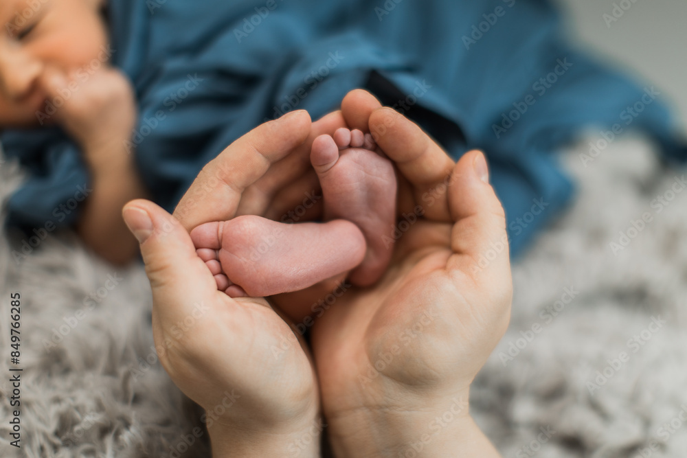 Mother's hands holding small baby's feet with love and care Mother's hands holding small baby's feet with love and care