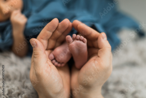 Fotografía Mother's hands holding newborn's baby boy tiny feet