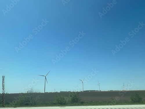 Panoramic view of wind farm or wind park, with high wind turbines for generation electricity with copy space. Green energy concept.